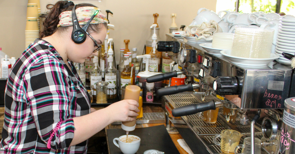 Savannah carefully crafts a signature cup as a skilled barista.