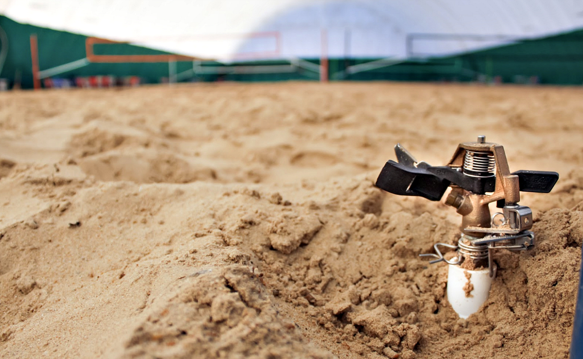 Sprinklers help keep sand from drying out inside the Volleyball Beach dome