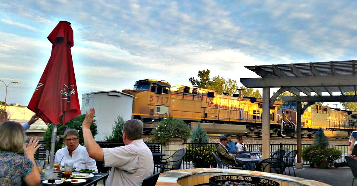 Patio dining at Jess & Jim's Steakhouse often includes a train passing by.