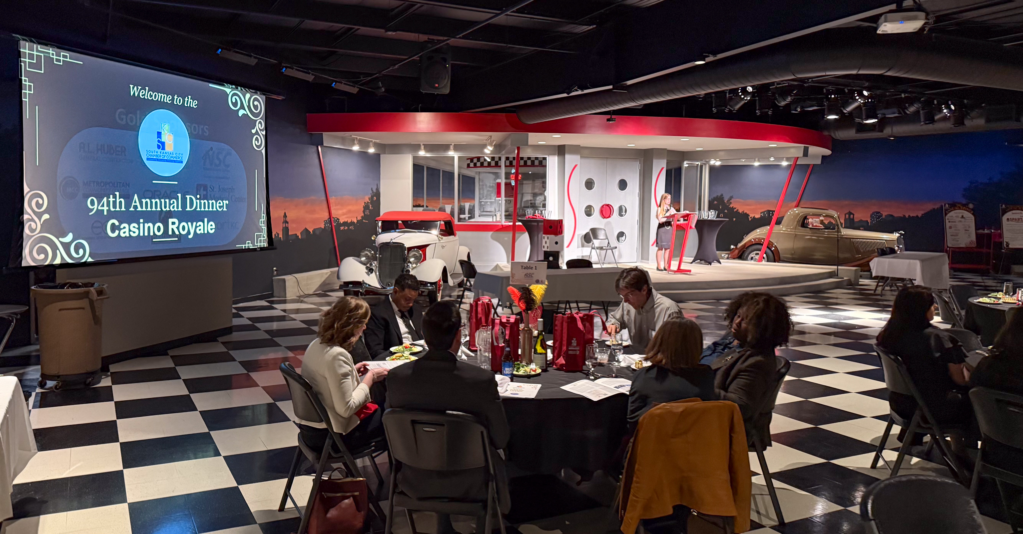 View of the crowded conference room and large sign, site of the 2025 South Kansas City Chamber Impact Awards Dinner